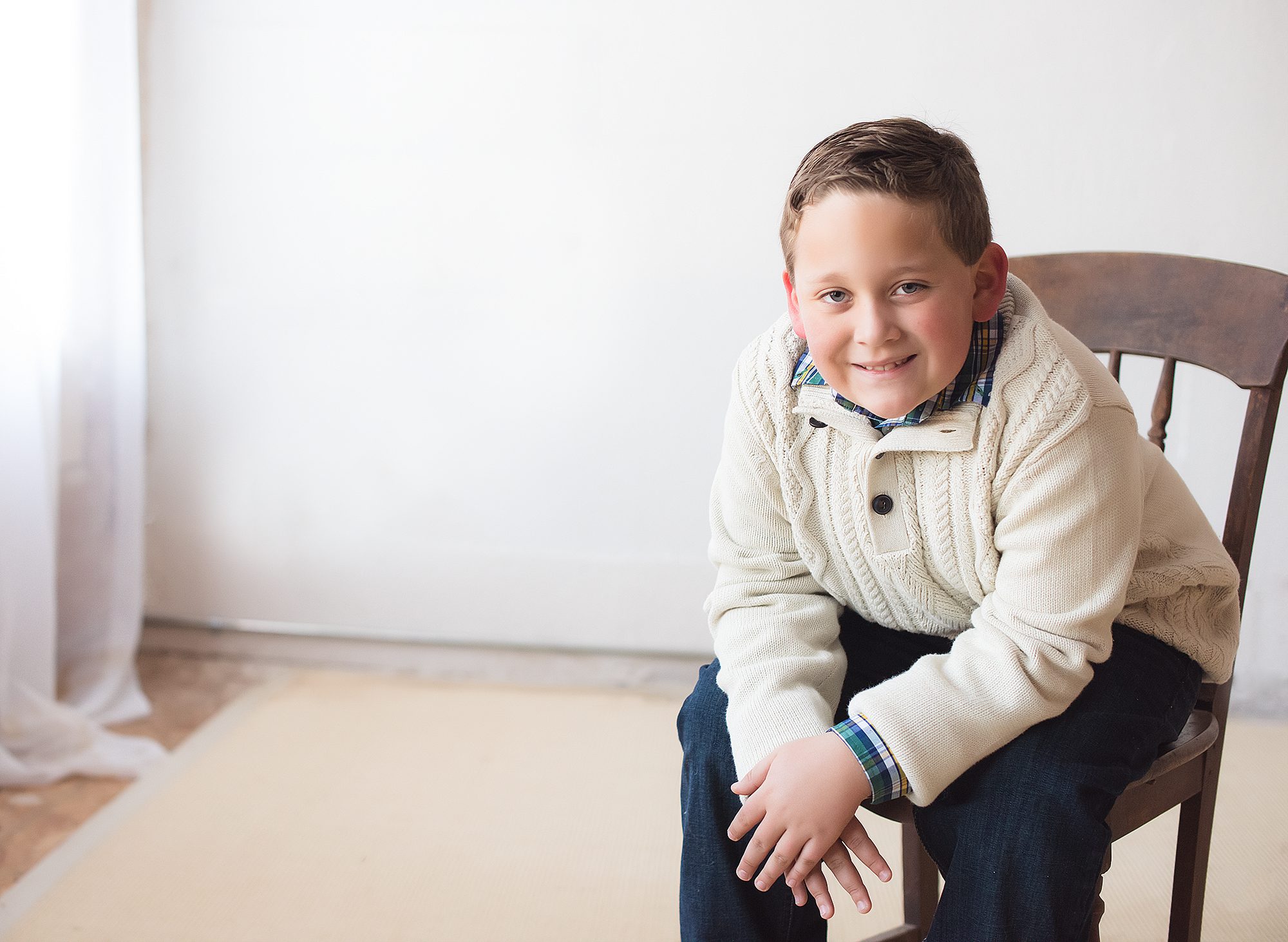 young grade school boy sitting in a chair