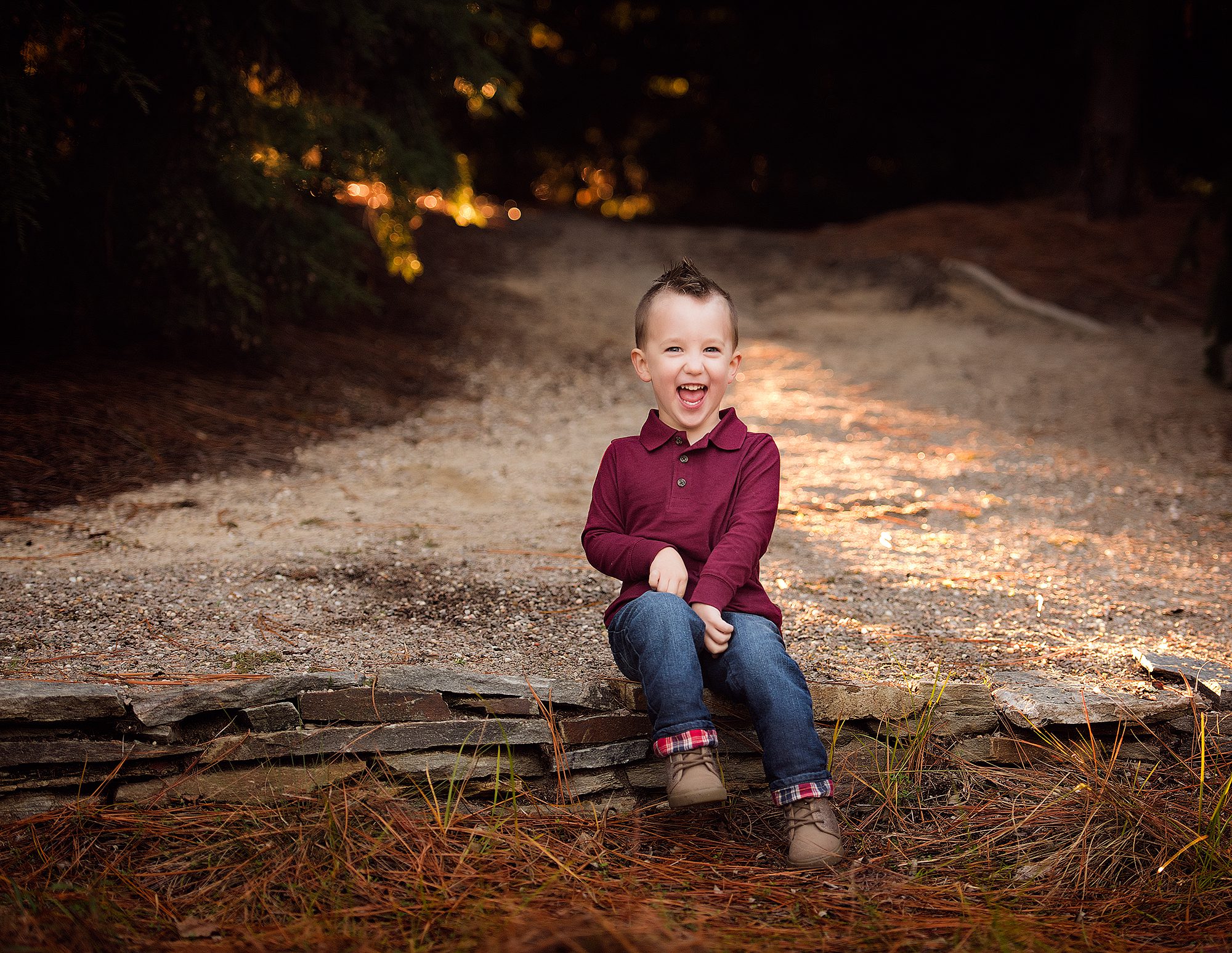 laughing boy wearing a maroon shirt