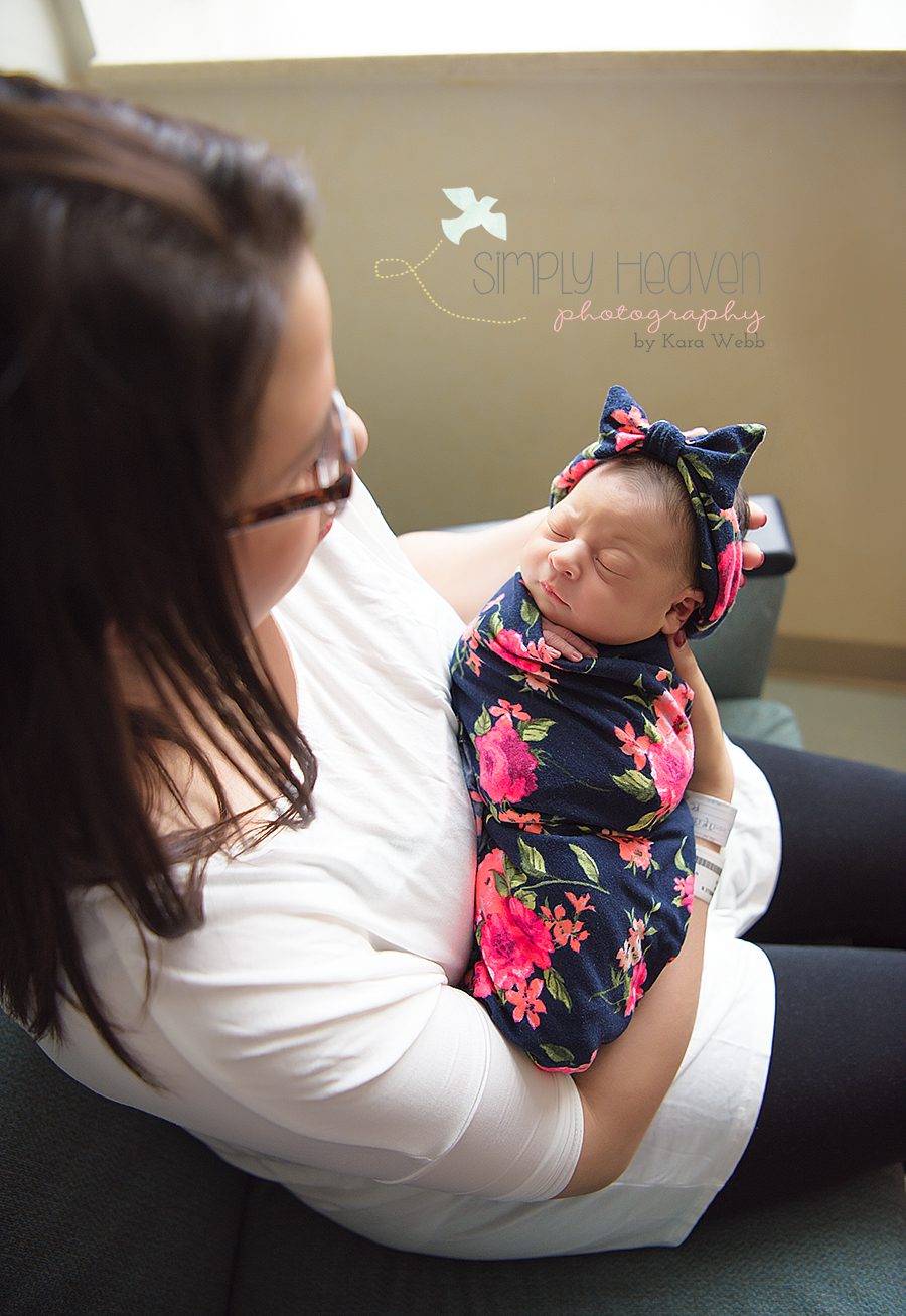 mom holding her swaddled newborn baby girl