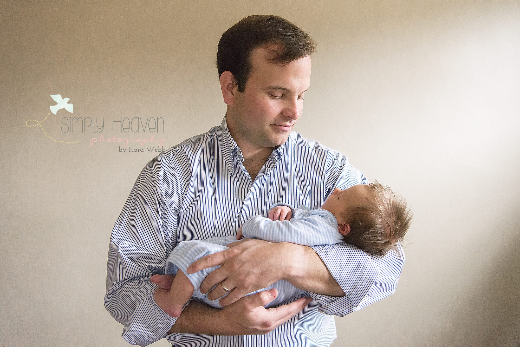 dad holding newborn baby boy during an inhome newborn baby session