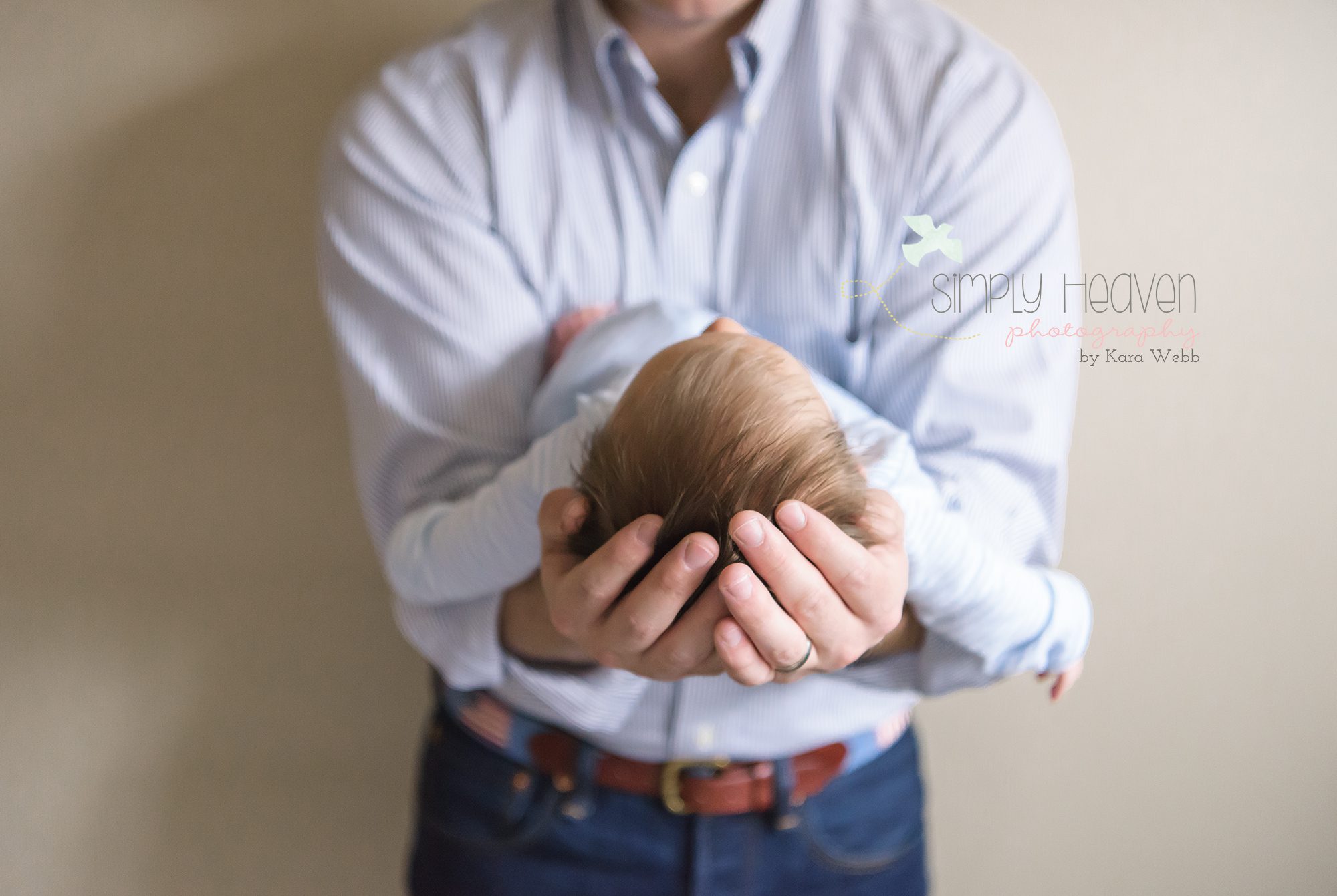 mom and dad holding newborn baby boy during a home newborn baby session