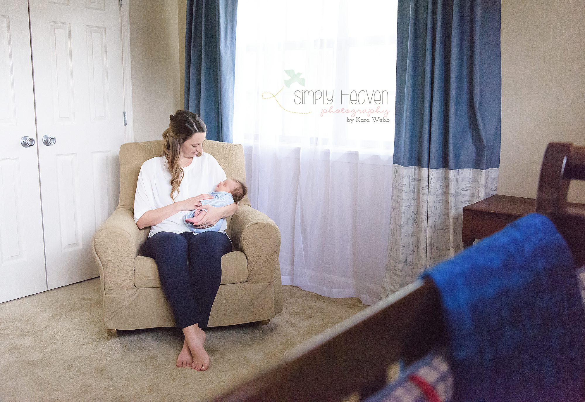 mom sitting in a chair and holding her newborn baby boy