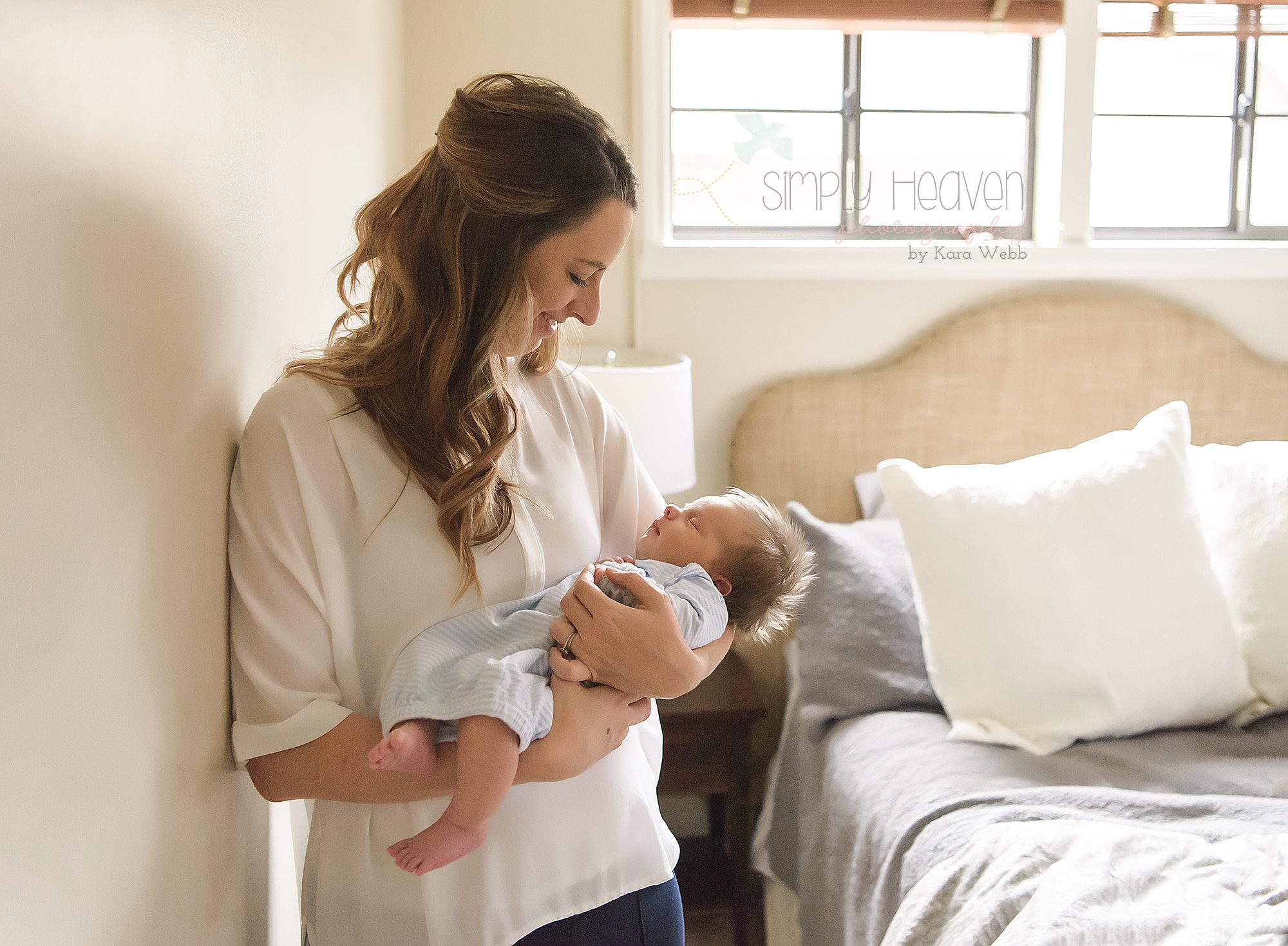 mom holding newborn baby boy during an in home newborn baby session