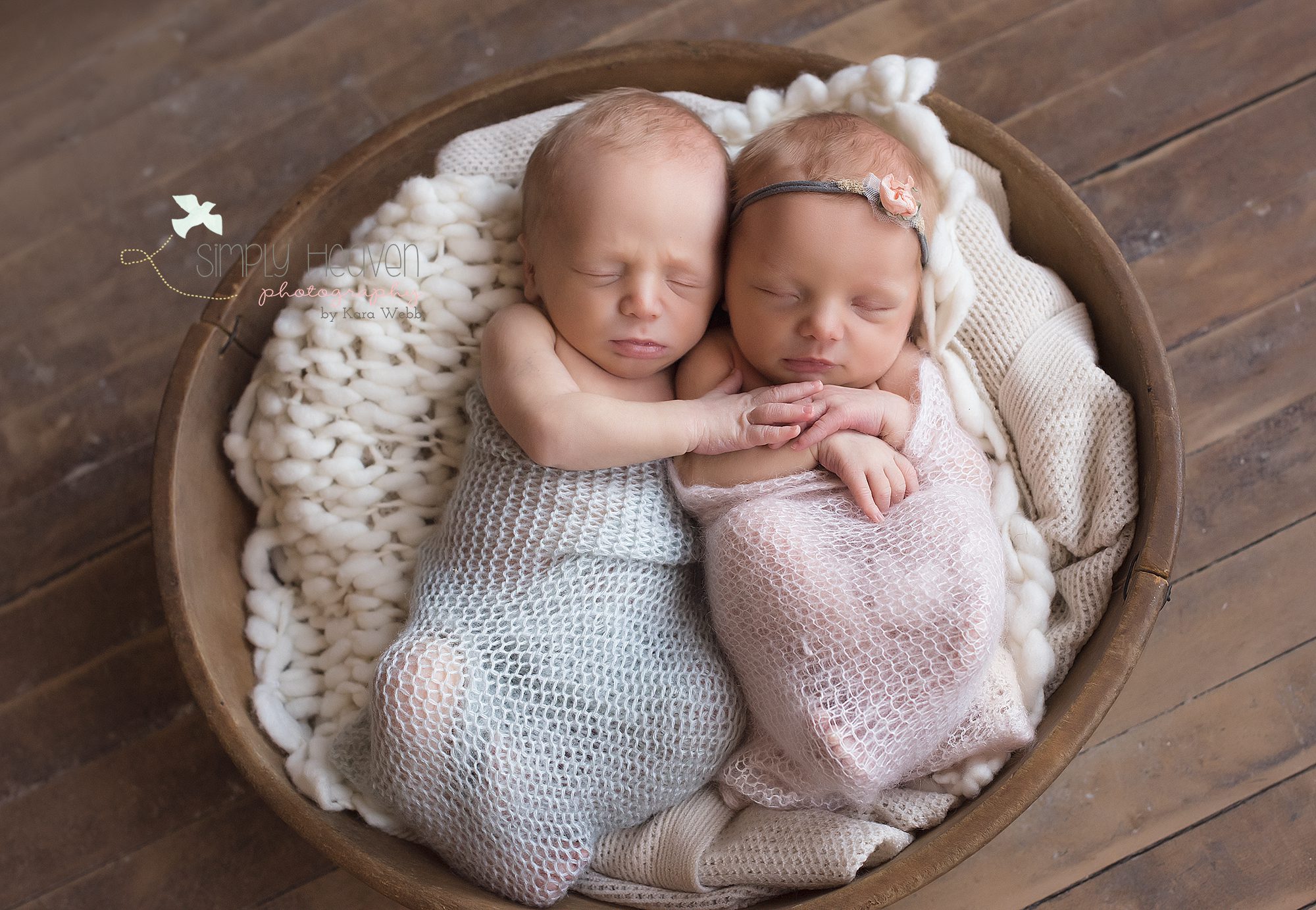 newborn twins snuggled in a bowl