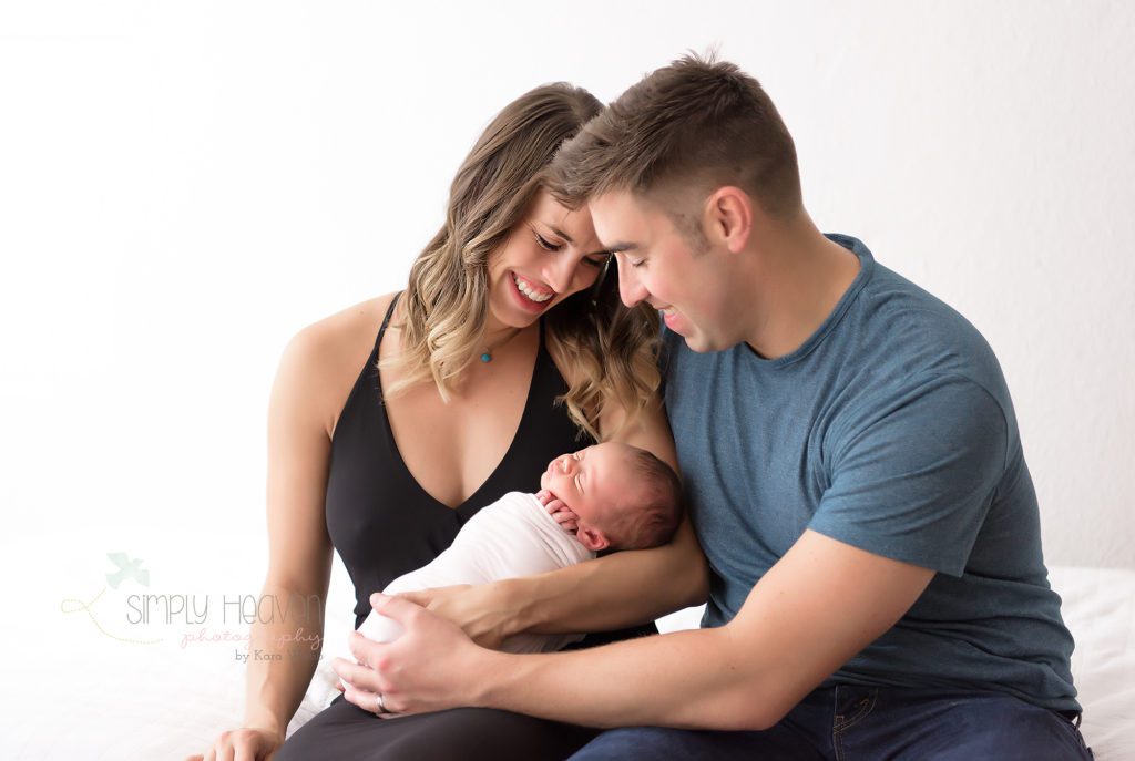 mother and father holding newborn baby boy